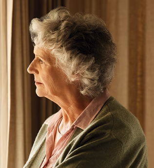 Photo of woman looking through a window