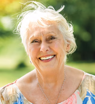 Photo of a woman smiling outdoors in the sun