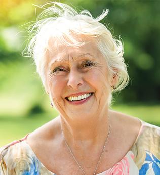 Photo of a woman smiling outdoors in the sun