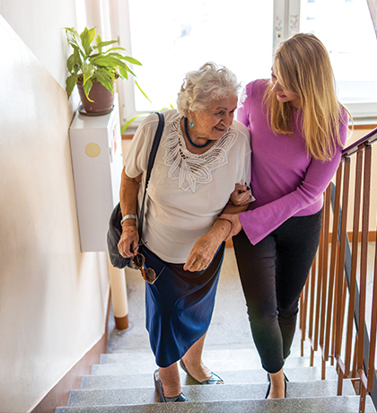 Photo of a woman helping another woman to climb stairs