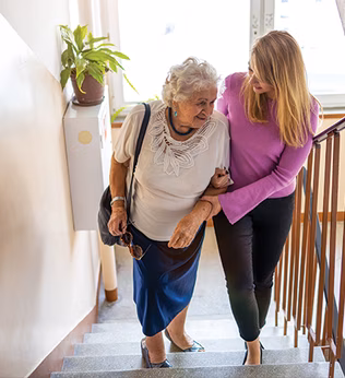 Photo of a woman helping another woman to climb stairs
