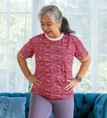 Photo of a woman standing on one leg in her lounge room