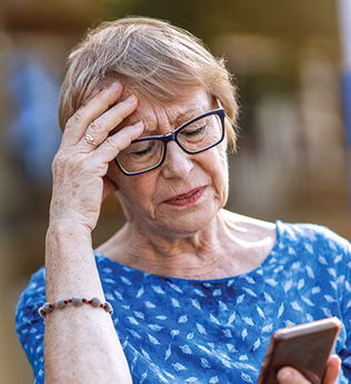Photo of a woman in blue top looking at her mobile phone