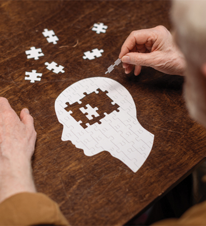 Photo of a man doing a jigsaw puzzle of a human head
