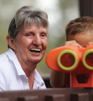 Photo of a woman with a small child and toy binoculars