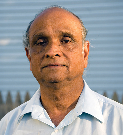 Photo of a man standing in front of a picket fence