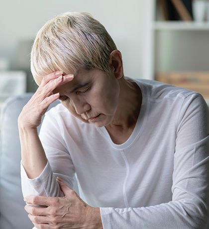 Photo of a woman with blonde pixie cut and white top