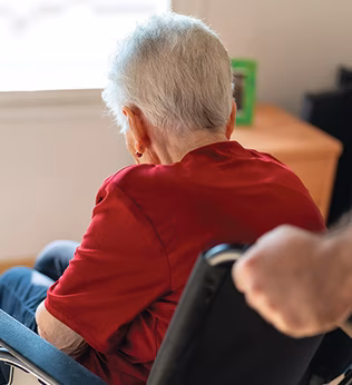 Photo of a woman wearing a red blouse in a wheelchair
