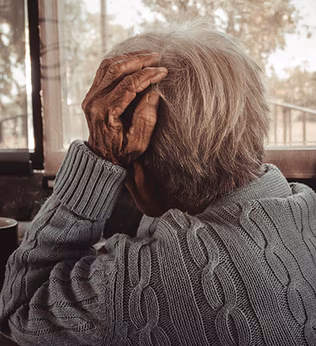 Photo of a seated woman with a cuppa looking outside