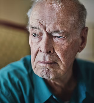 Photo of a man in a green shirt on a gold coloured setee