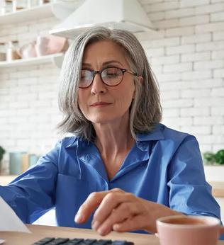 Photo of a woman in a blue shirt reading through paperwork