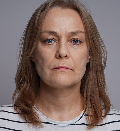 Photo of a woman in a striped top staring directly at the camera
