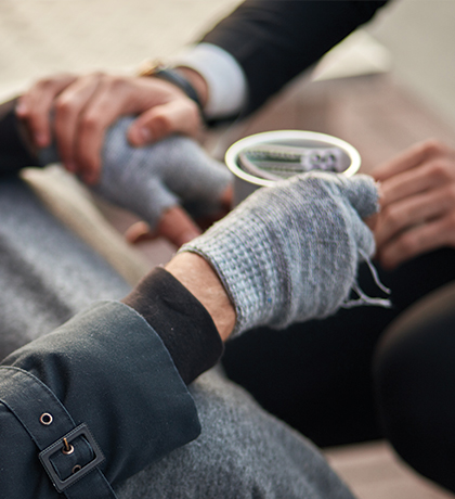 Photo of four hands an a cup with money in it