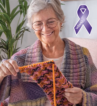 Foto einer Frau, die beim Stricken lächelt