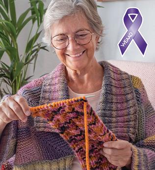 Photo of a woman smiling at her knitting