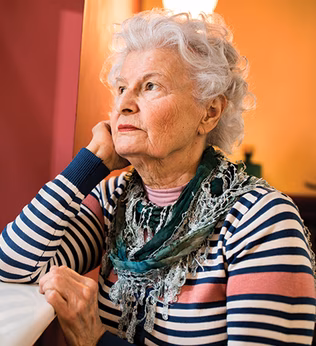 Photo of a woman with a striped top staring out a window