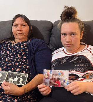 Photo of two women holding photographs