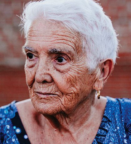 Photo of a woman with short white hair in a blue dress