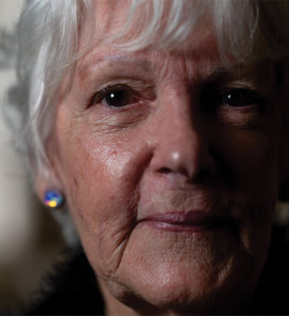 Photo of a woman with a sparkly earring in a darkened room