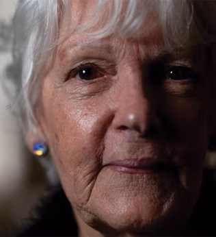 Photo of a woman with a sparkly earring in a darkened room