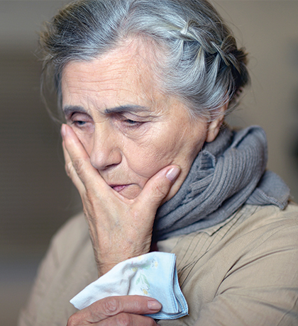 Photo of a woman with a hankie and her hand over her mouth