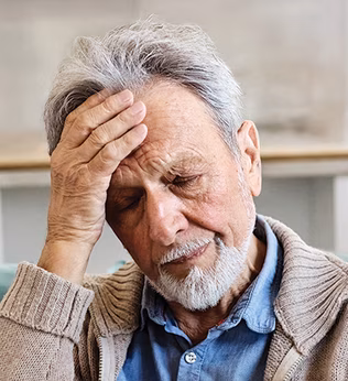Photo of bearded man with hand on his forehead