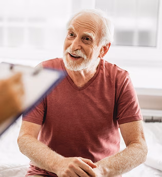 Photo of a patient in a red t-shirt talking to a health worker