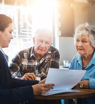 Photo of woman with a chignon showing some documents to an older couple