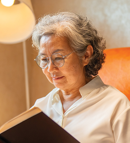 Photo of a woman in a comfortable chair reading a book