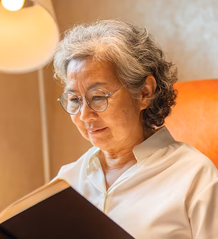Photo of a woman in a comfortable chair reading a book
