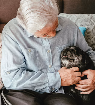 Photo of a man with a black pug dog