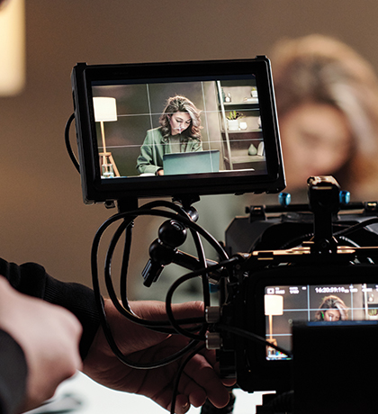 Photo of a the monitor attached to a video camera with a woman in the frame