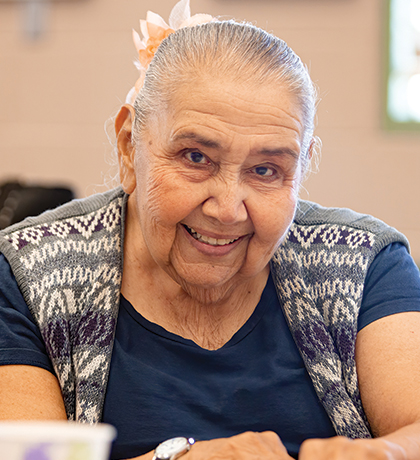 Photo of a smiling woman seated next to a lady in pink