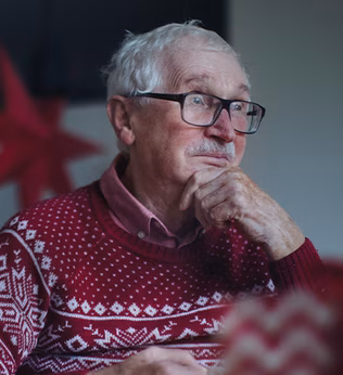 Photo of a man wearing a red and white christmas jumper