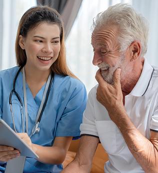 Photo of woman in scrubs discussing something with man