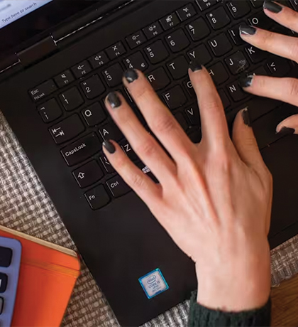 Photo of hands with black painted nails on a keyboard