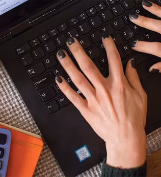 Photo of hands with black painted nails on a keyboard