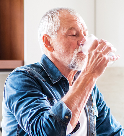 Photo of a man drinking a glass of water