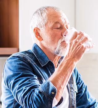 Photo of a man drinking a glass of water