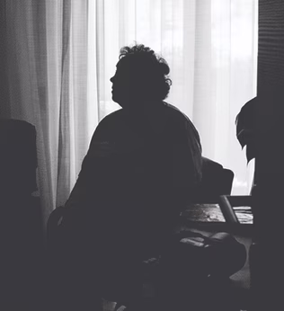Image of older person sitting in the dark