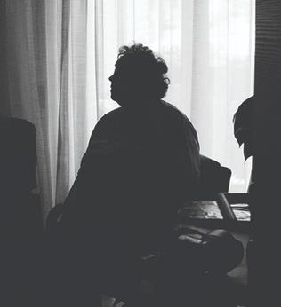 Image of older person sitting in the dark
