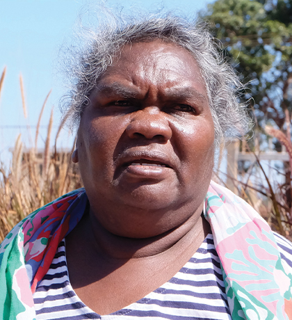 Photo of a woman in a striped top outdoors on a sunny day