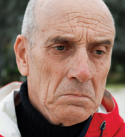 Photo of a glum man wearing a red jacket