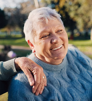 Photo of woman in a blue cable knit jumper smiling