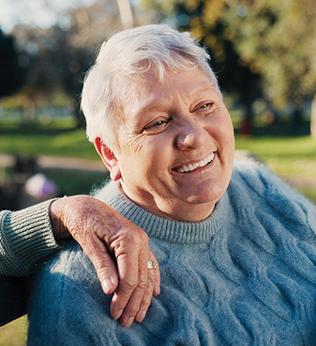 Photo of woman in a blue cable knit jumper smiling