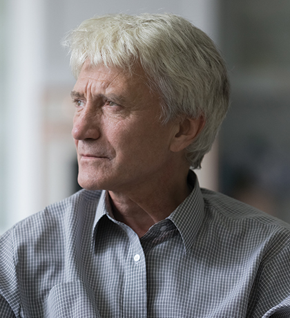 Photo of a man with white hair and a grey check shirt