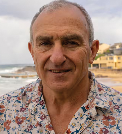 Photo of a man in a floral shirt on a beach