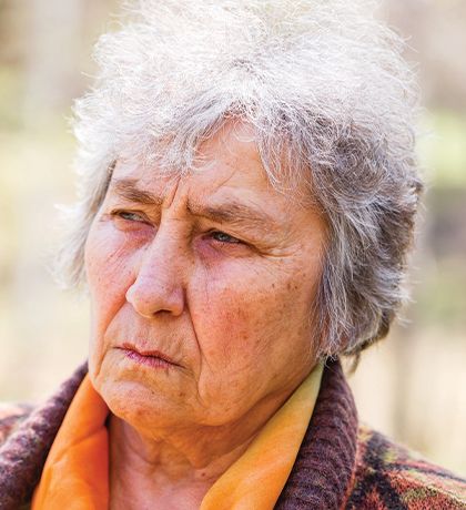 Photo of a woman wearing an orange blouse and a woolly cardigan