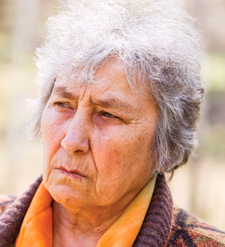 Photo of a woman wearing an orange blouse and a woolly cardigan
