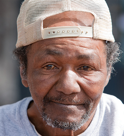 Photo of a man wearing a cream cap backwards